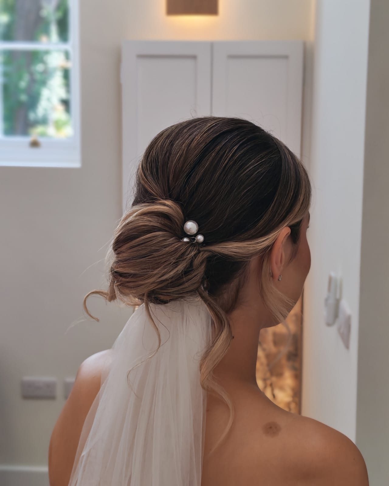 Elegant bridal bun finished with pearls and a veil
