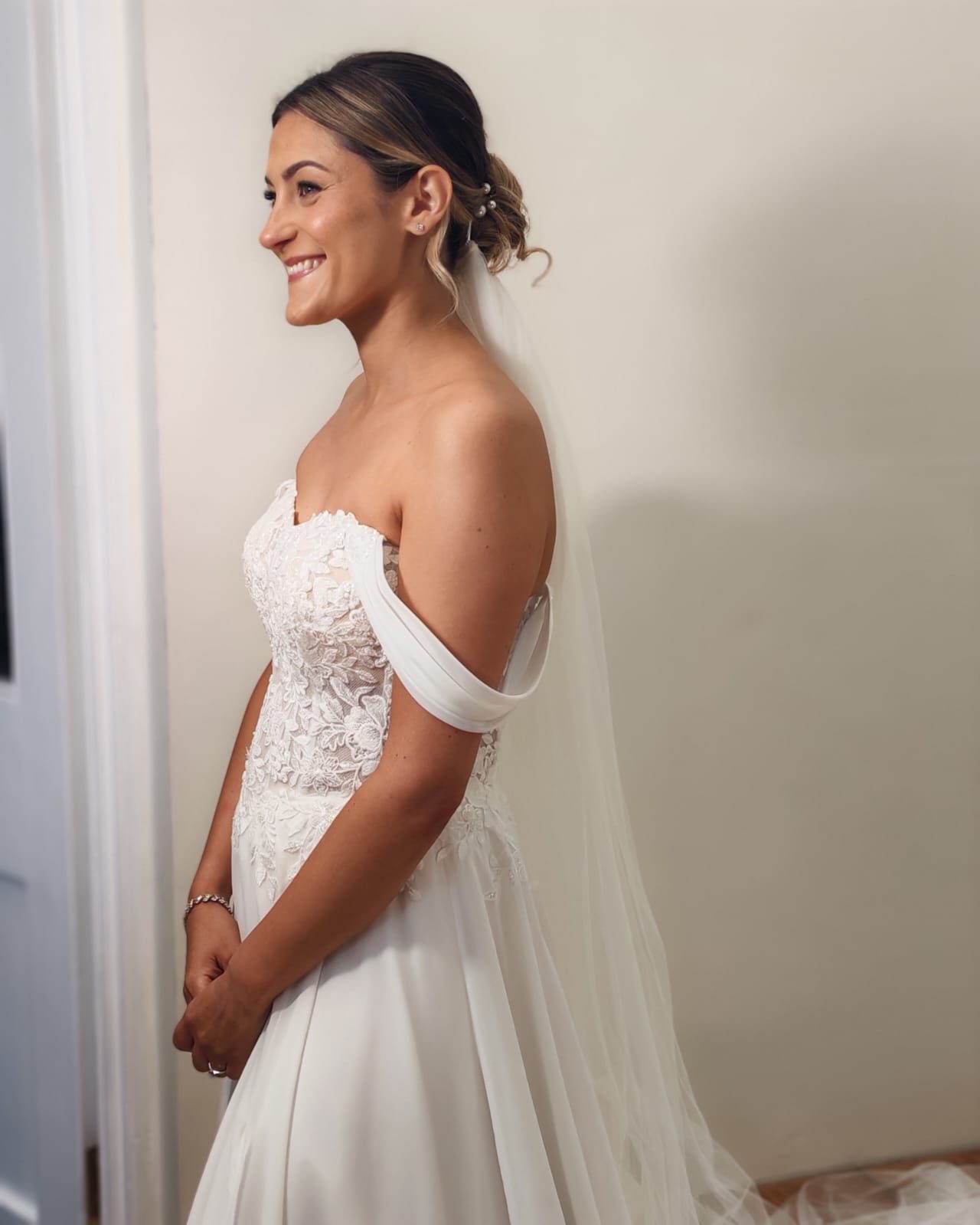 Bride wearing an elegant low bun, veil and natural wedding makeup
